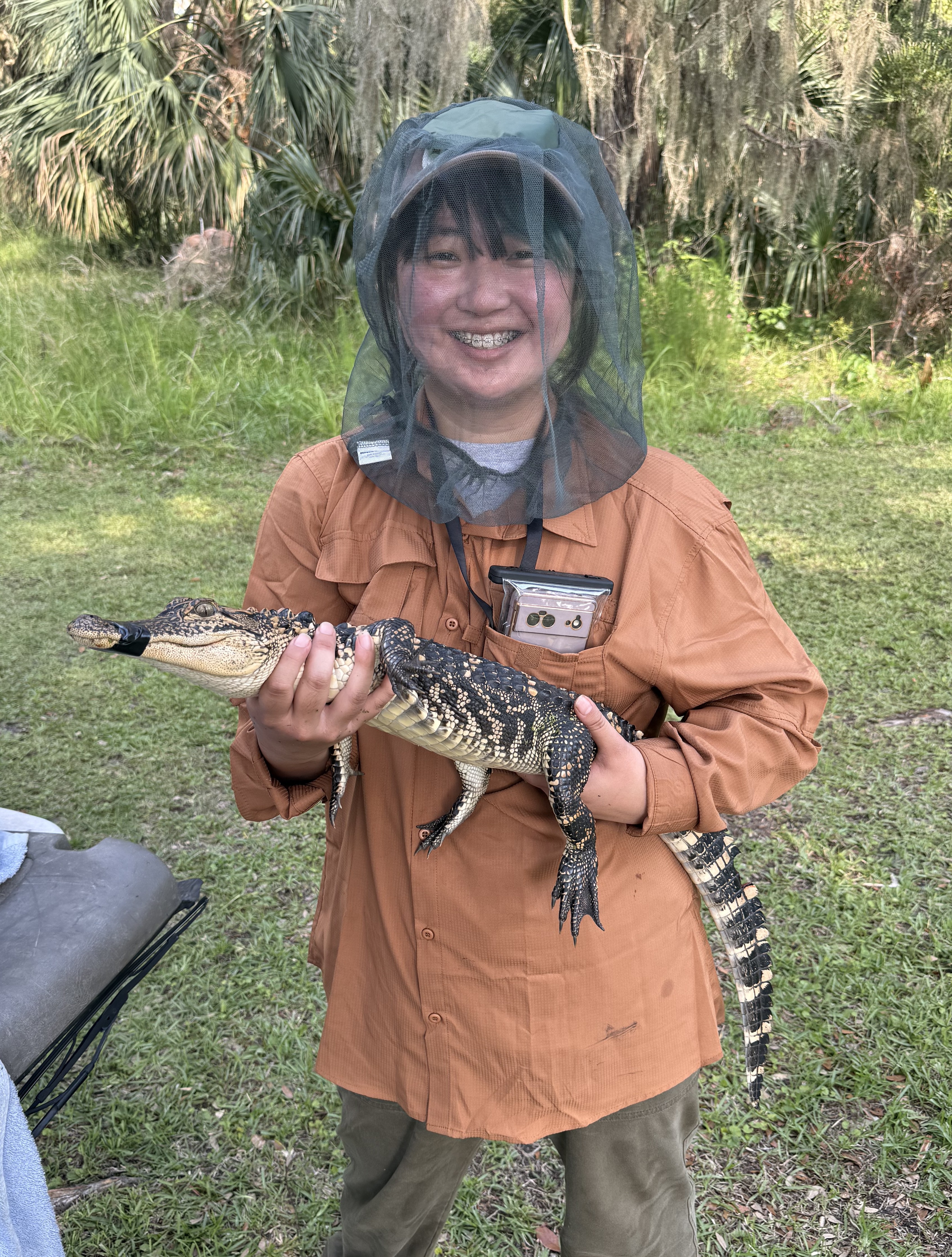Mayu holding an alligator.